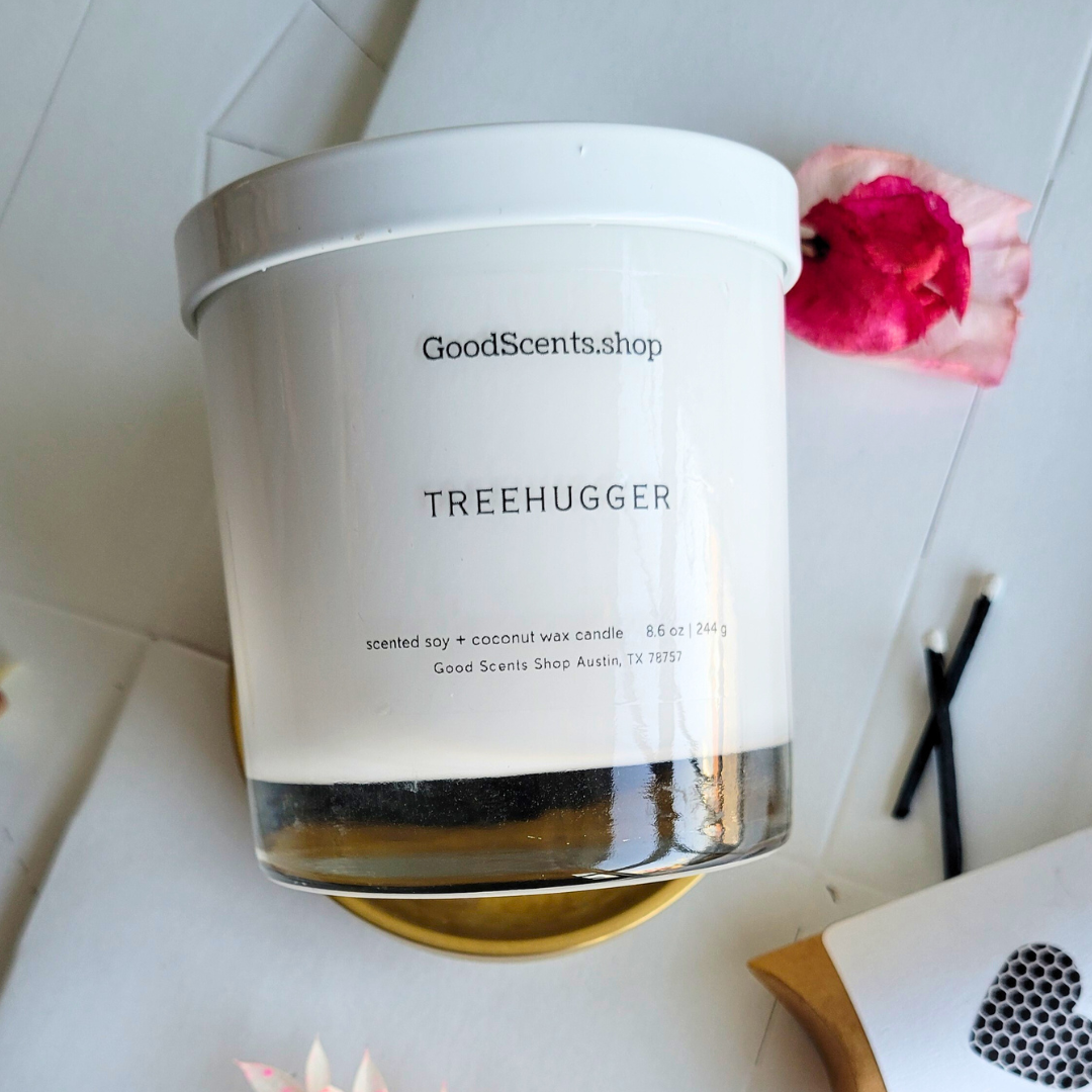 good scents shop white candle tumbler in treehugger scent on a white background with black matched and dried flowers
